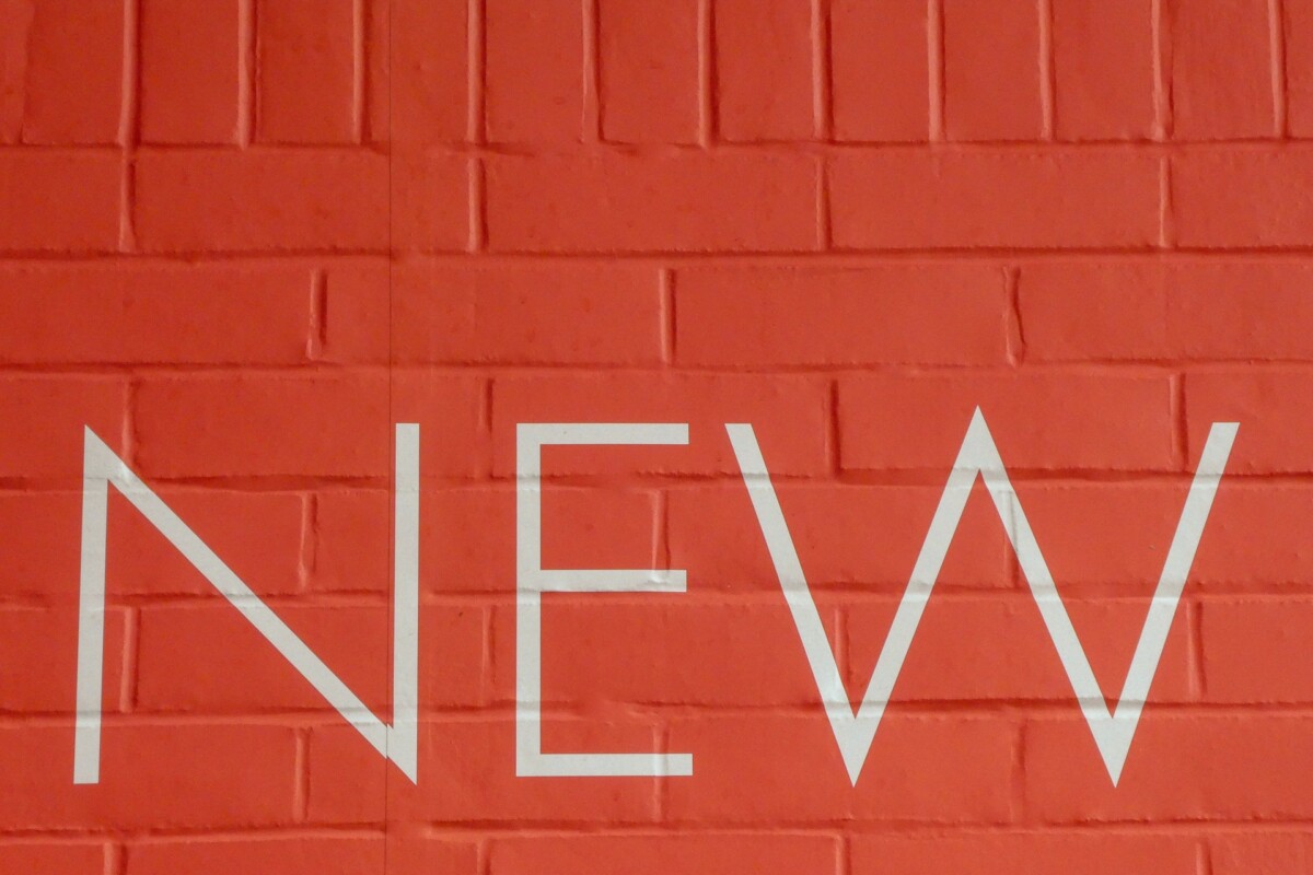 'NEW' sign in white paint on a terracotta brick wall. Photo: Nick Fewings on Unsplash.com