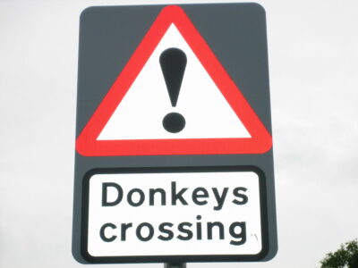 Donkeys crossing warning sign - triangular road sign outside the Donkey Sanctuary, Devon - photo: Howard Lake