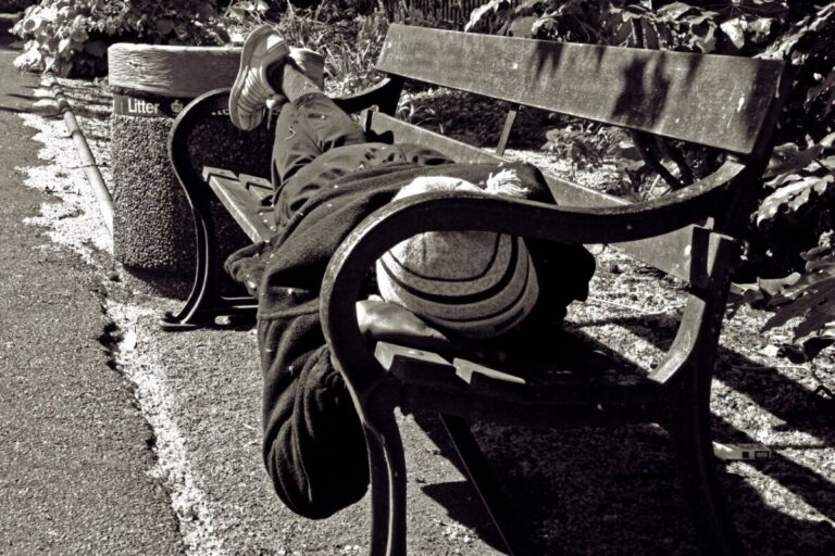 Homeless person on a bench. Black and white.