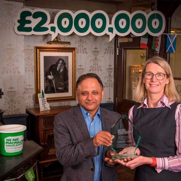 Rooney Anada and Lynda Thomas beneath a £2,000,000 celebration banner.