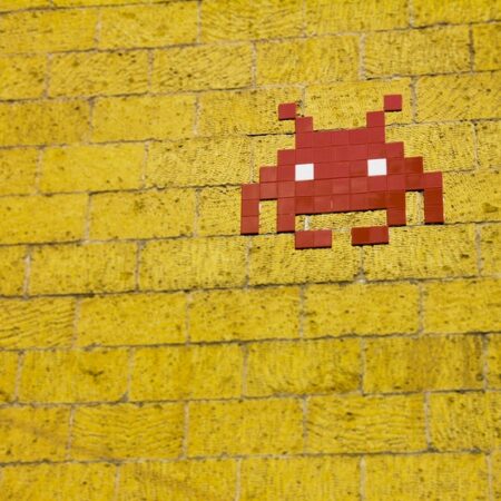 Space Invaders icon on a yellow wall - photo: Pexels.com