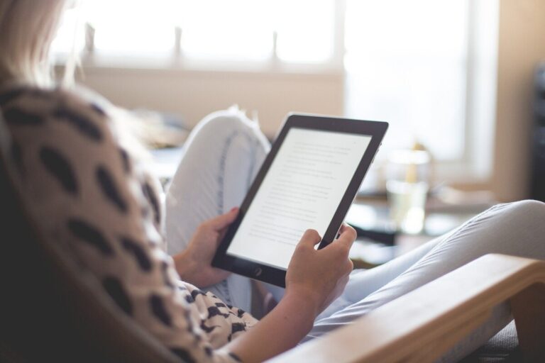 A woman reading from a Kindle