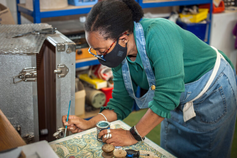 A woman painting some furniture