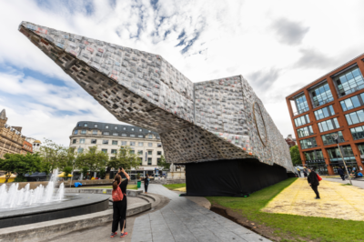 Big Ben Lying Down With Political Books, by Marta Minujín.