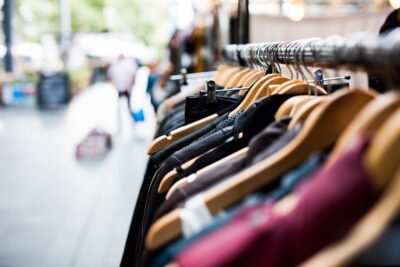 A row of women's clothes hanging on a rail in a shop