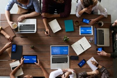 Looking down at a crowd of people have a business meeting around a wooden table