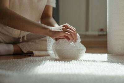 Hands wrapping an item in bubblewrap