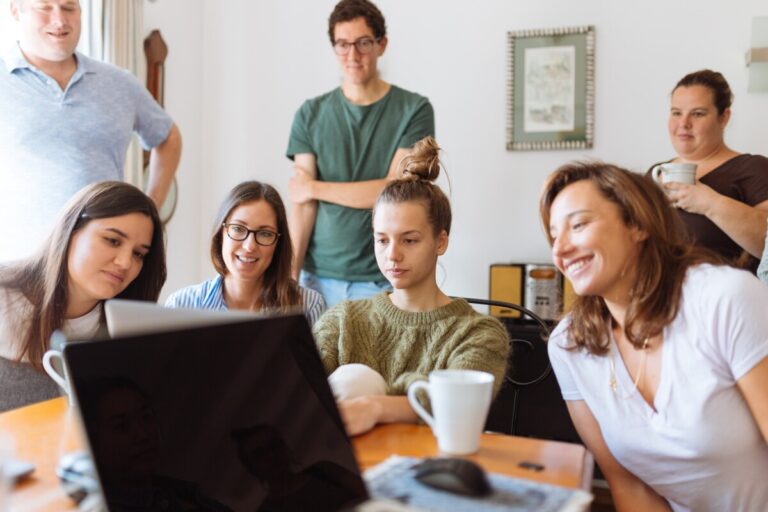 A family sitting around a computer screen