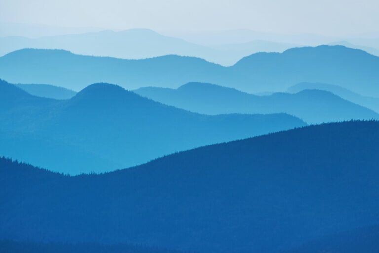 Mountains receding into the distance. All are different shades of blue, getting lighter the further away they are.