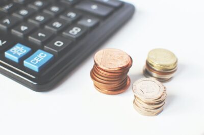 A calculator and piles of coins