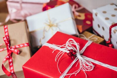 a pile of christmas presents wrapped in red, white, and brown Christmas paper and ribbons