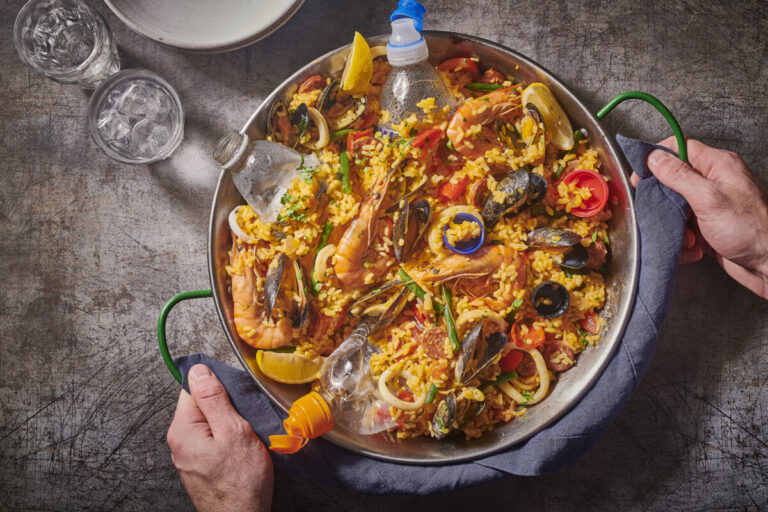 A dish of paella with plastic waste in it