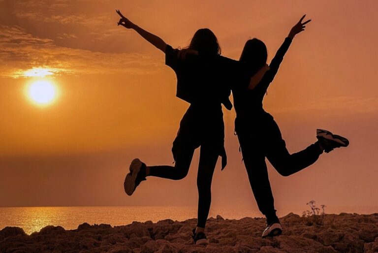 2 girls silhouetted against the setting sun