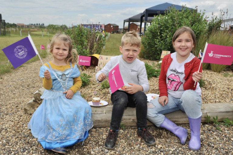 Children wave flags for the Platinum jubilee at the People & Animals tea party