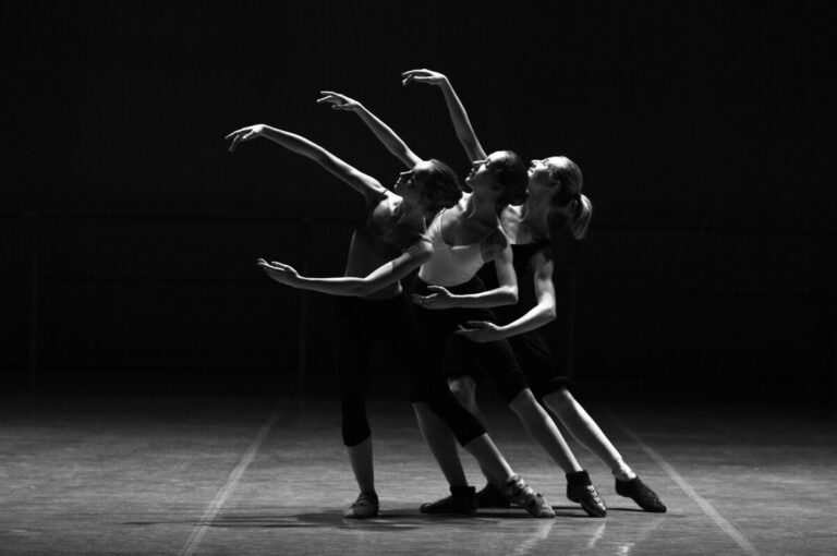 3 dancers raise their arms as one. By Pixabay on Pexels