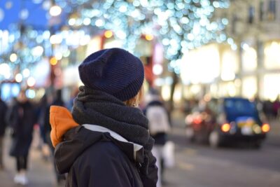 The back of a woman in a black hat and coat, against the blurred background of a london street. By Lorskull on Pixabay