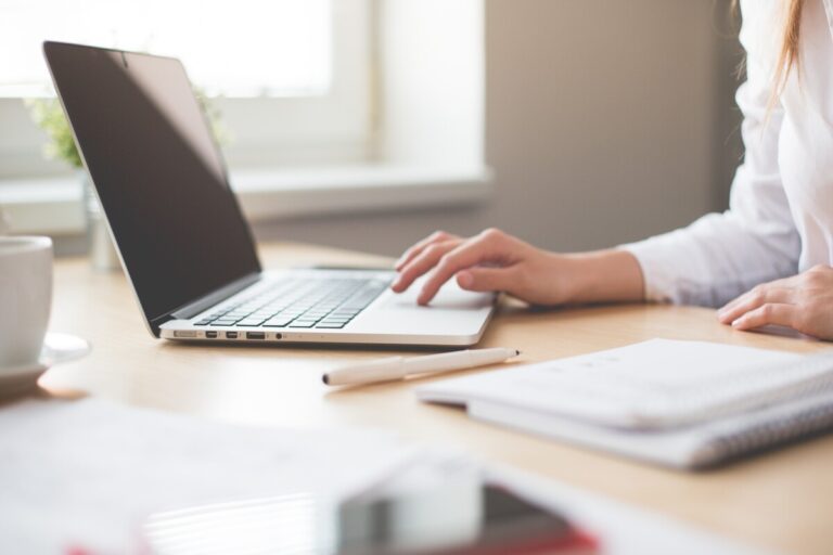 A woman at a laptop with a notebook. By Picjumbo.com on pexels