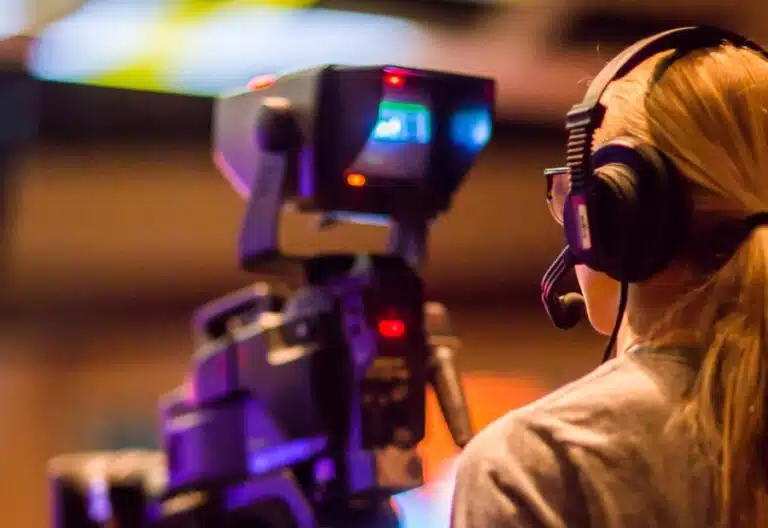 A woman filming with a big camera. By Caleb Oquendo on Pexels