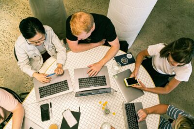 A shot looking down on a group of people working on laptops. By Canva Studio on Pexels