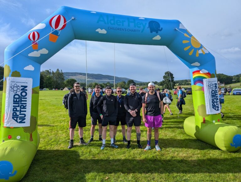 Standing under an event arch, the BusinessComparison team take on the Coniston Challenge