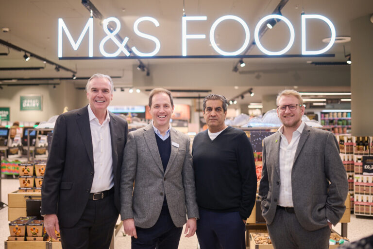 A line of men standing in an M&S Food store. From left to right: Ronald Kers, Group CEO of Valeo Foods Alex Freudmann, Managing Director at M&S Food Ranjit Singh Boparan, Founder and President of 2 Sisters Food Group Kris Gibbon-Walsh, CEO of Fareshare. By Freelance Events Photographer