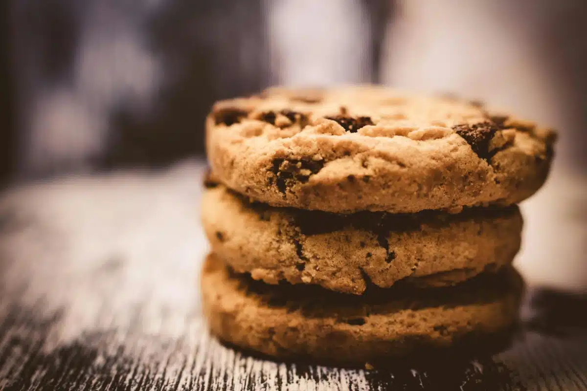 A stack of three chocolate chip cookies. By Lisa Fotios on pexels