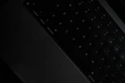 Image of a black keyboard, presented at a slant, with a very dark background. By Sai Abhinivesh Burla on unsplash