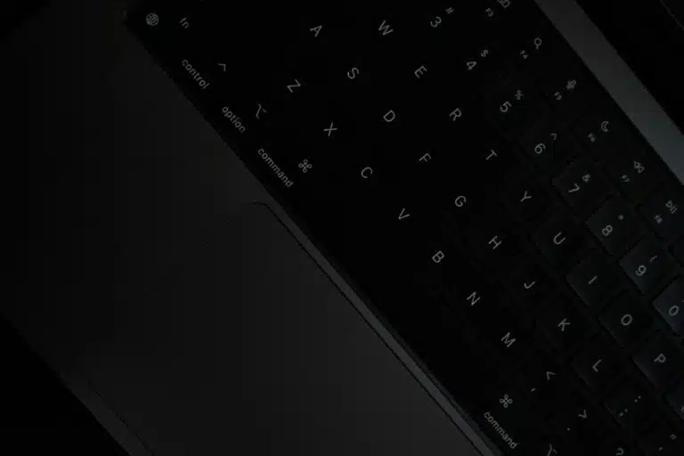 Image of a black keyboard, presented at a slant, with a very dark background. By Sai Abhinivesh Burla on unsplash