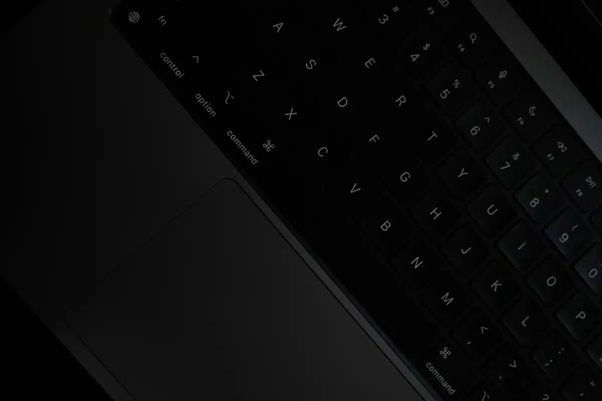 Image of a black keyboard, presented at a slant, with a very dark background. By Sai Abhinivesh Burla on unsplash