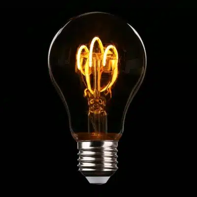 Lightbulb glowing against a dark background.