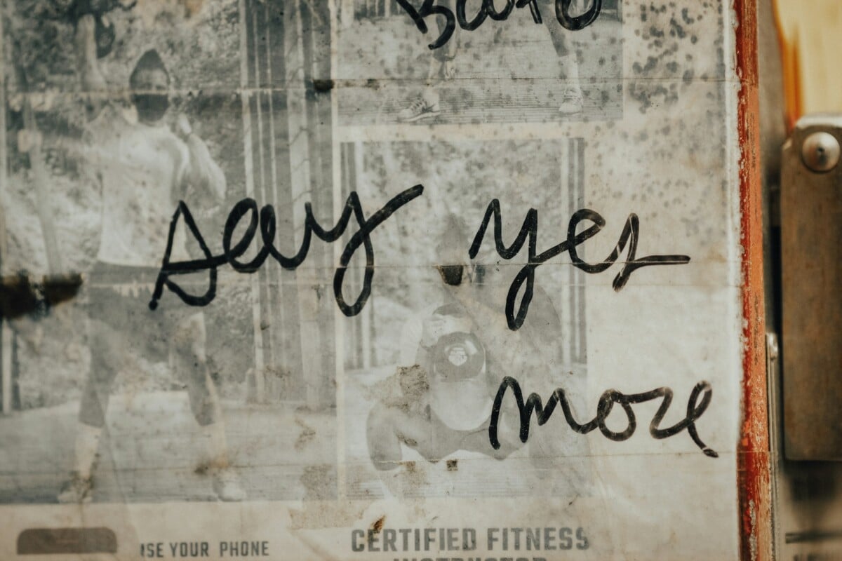 Say yes more - handwriting on a poster or leaflet.