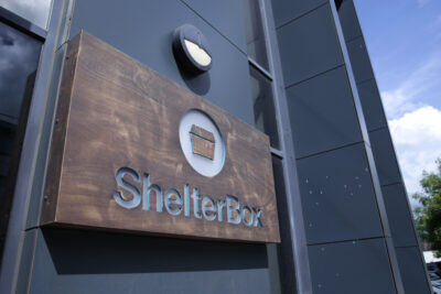 Shelterbox logo on a wooden panel outside their Truro office
